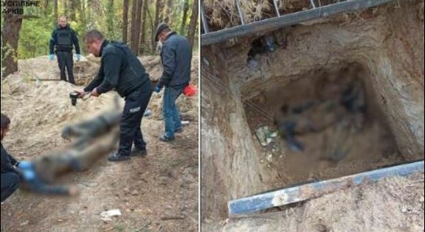 Ucraina, i cadaveri di due civili scoperti in una fossa comune: le foto choc, torturati e ammanettati insieme