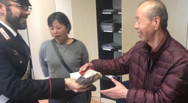 Il carabiniere consegna il portafogli al turista giapponese derubato