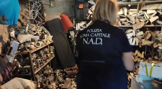 Un agente ispeziona un deposito clandestino di pezzi di elettrodomestici a Tor Bella Monaca