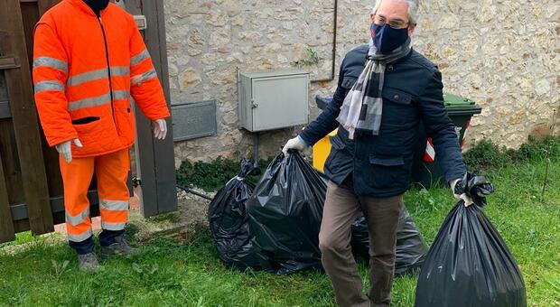Guido Grillini, sindaco di Calvi dell'Umbria, mentre trasporta i sacchi di immondizia indifferenziata